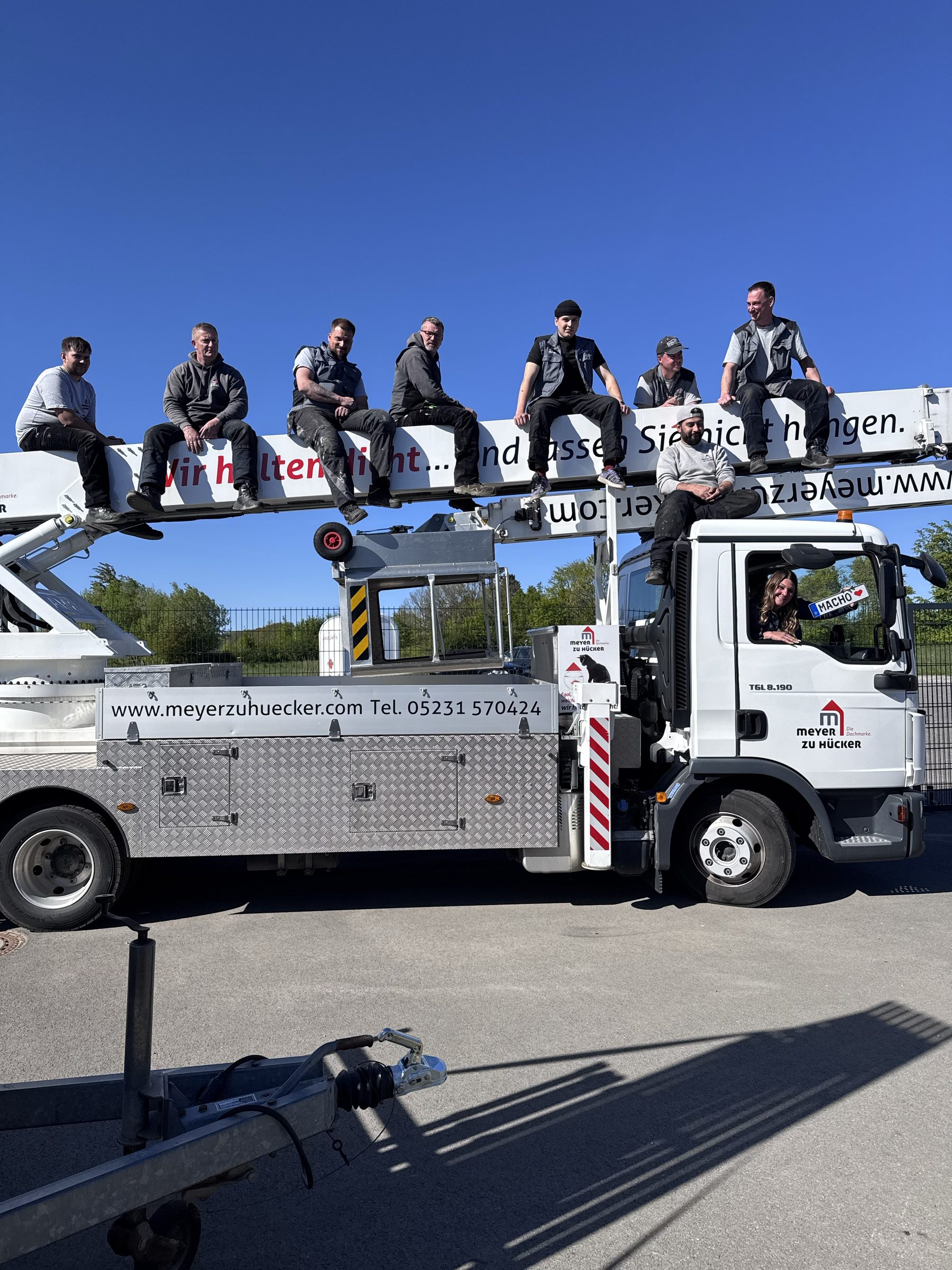 Team sitzt auf Kran-Ausleger